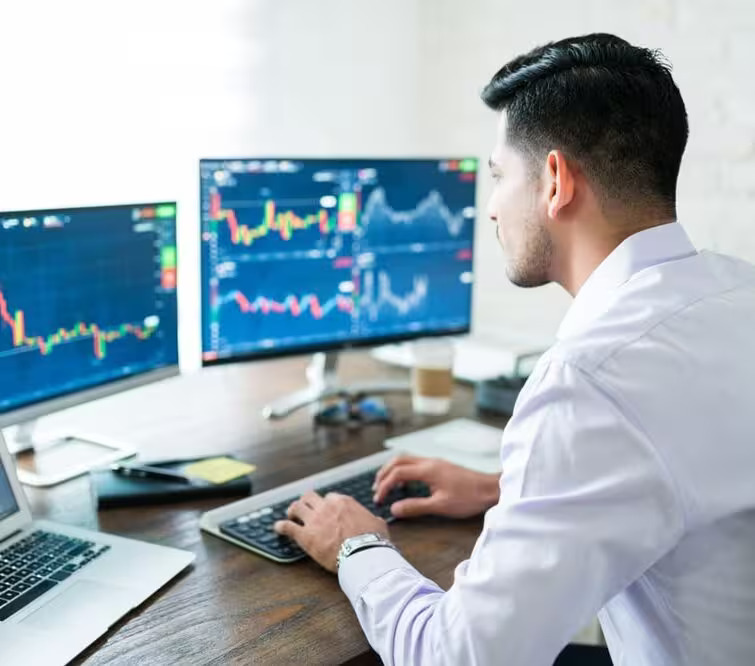 Equipo de trading colaborando mientras analiza gráficos financieros